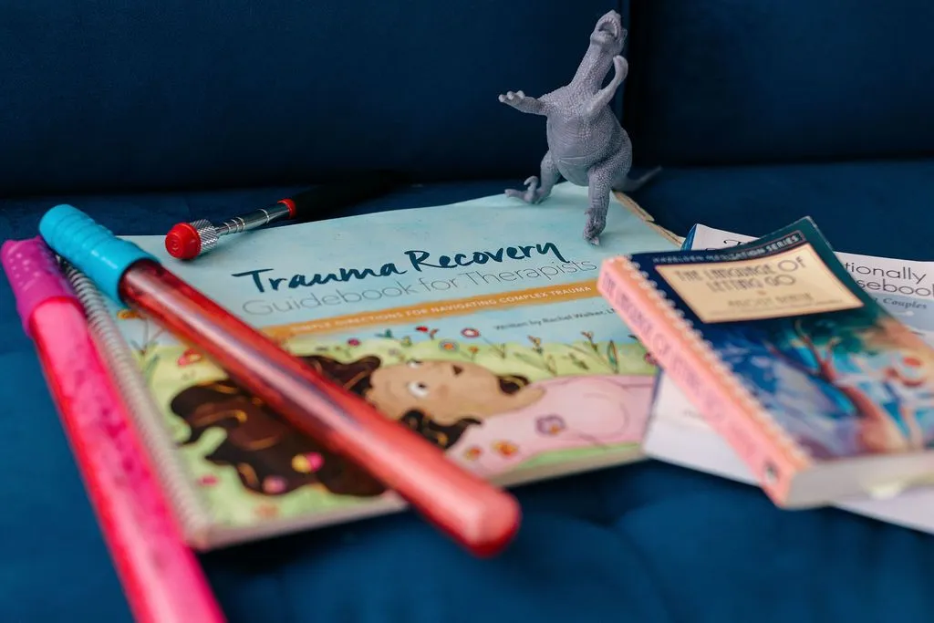 Trauma recovery guidebook, EMDR tappers and a parts-work figure used in Susana Romero's Visalia therapy office