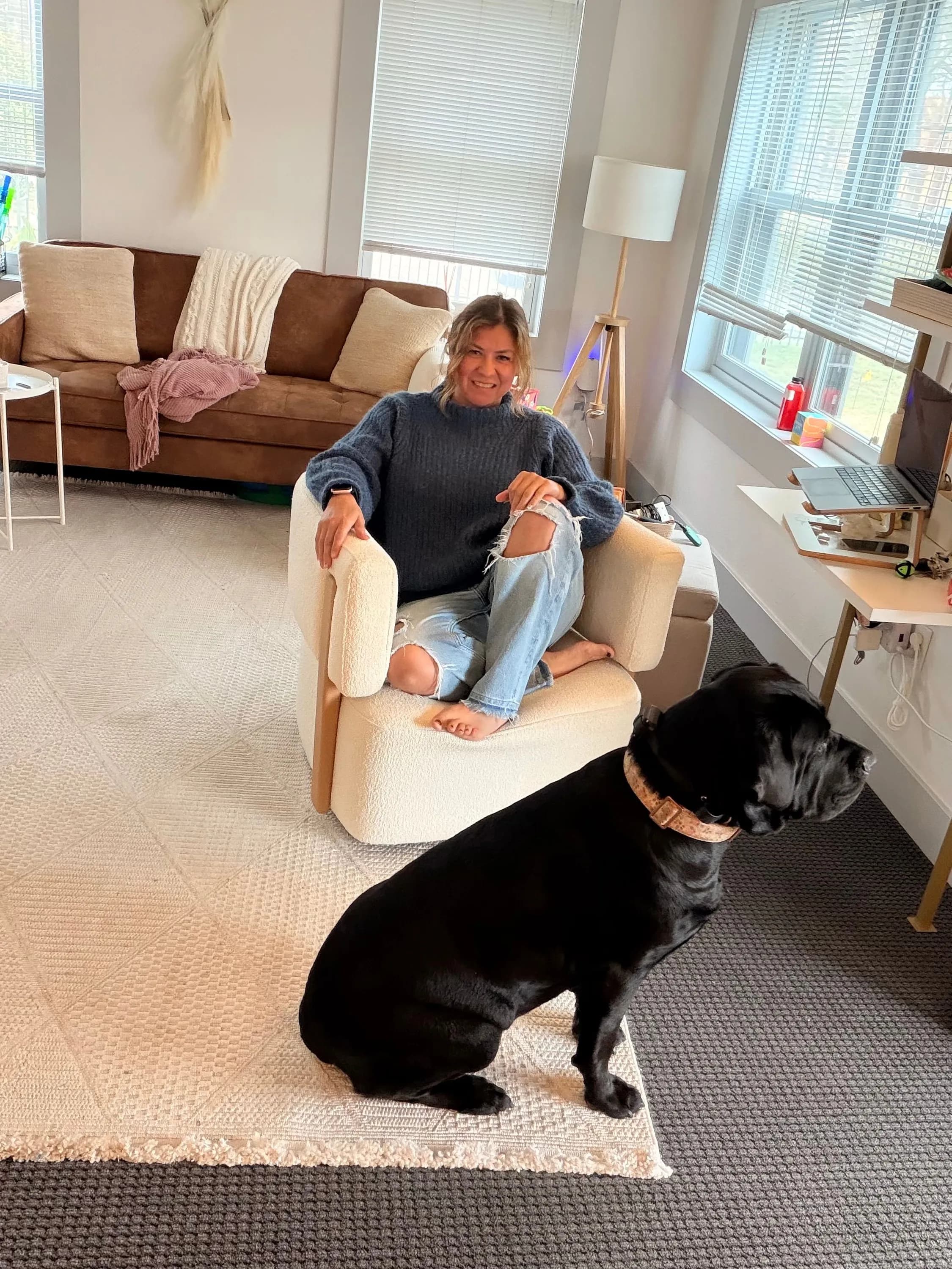 Susana Romero, LMFT, a bilingual therapist in Visalia, CA, seated in a warm, sunlit room with her dog